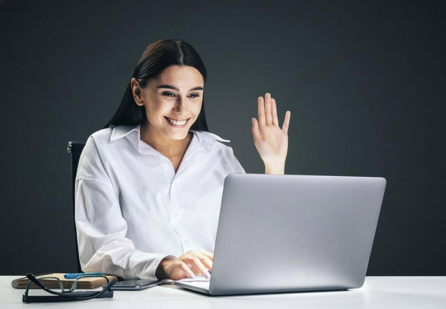 Smiling IT support specialist helping a client over a video call from a Dubai office